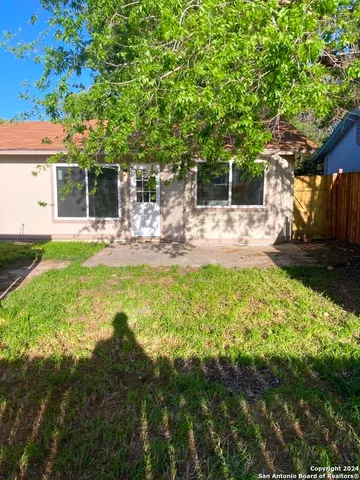 a view of a house with backyard and sitting area
