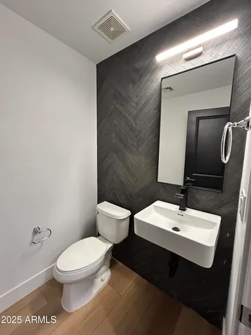 a bathroom with a toilet a sink and mirror