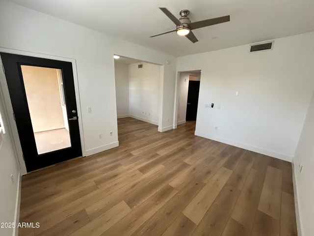 a view of a room with wooden floor and a ceiling fan
