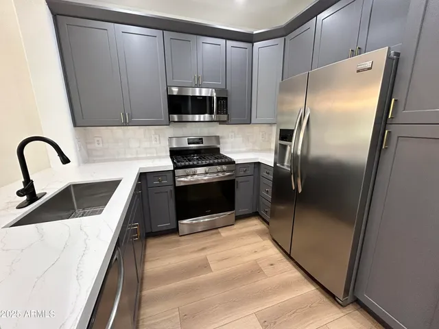 a kitchen with stainless steel appliances kitchen island a refrigerator sink and stove