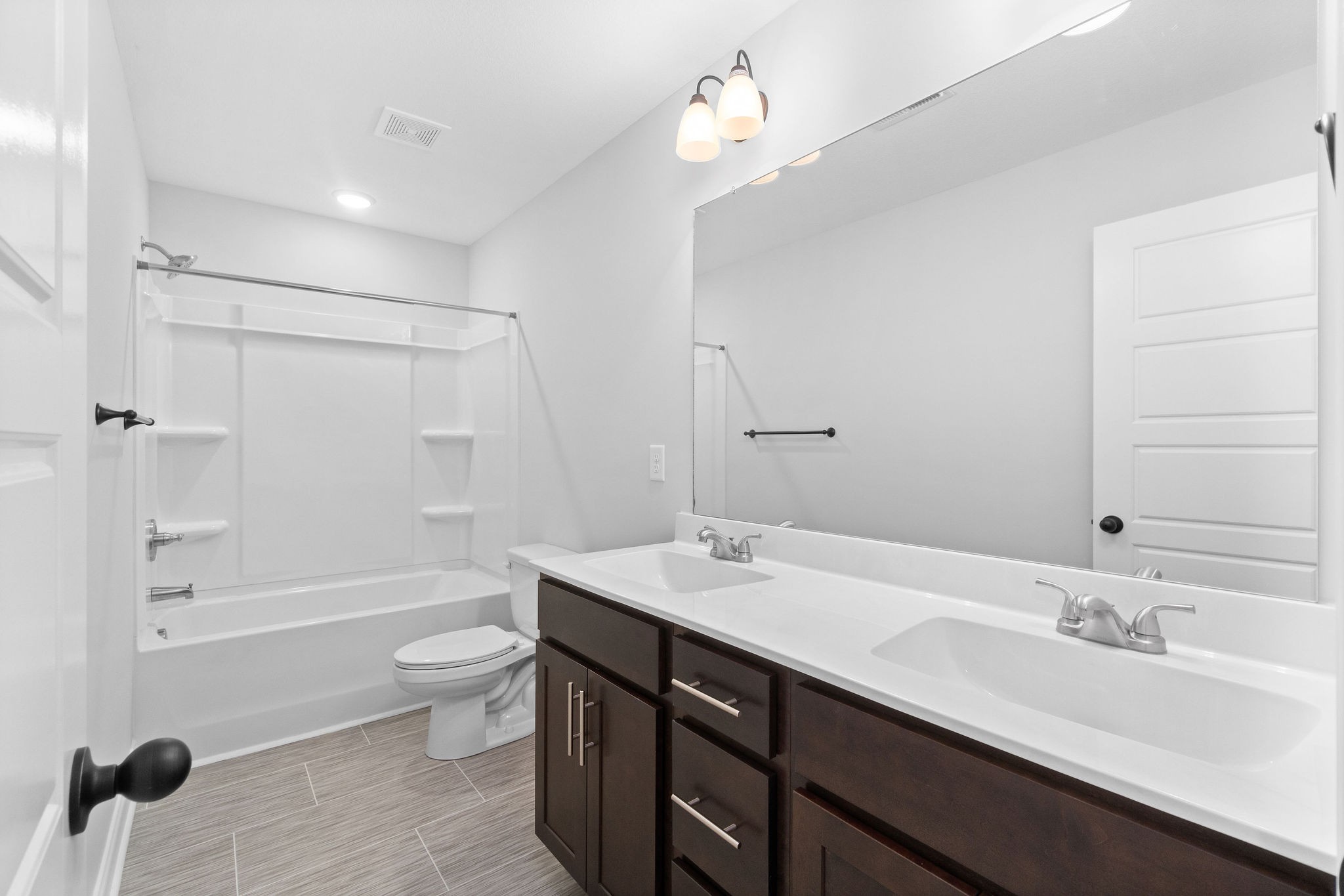 64 West High Street Clarksville, TN 37040 - Photo 17 of 22 a bathroom with a double vanity sink a toilet a mirror and shower