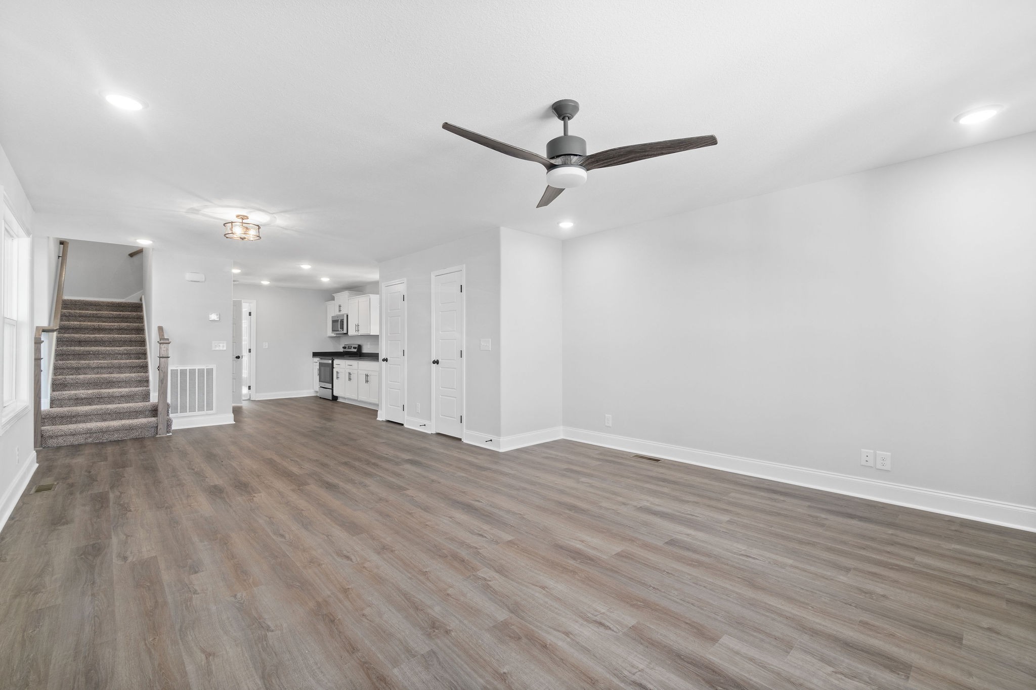 64 West High Street Clarksville, TN 37040 - Photo 6 of 22 an empty room with wooden floor a ceiling fan and kitchen view