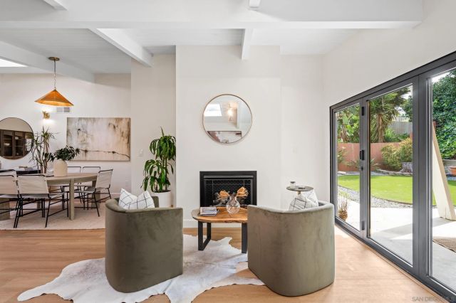 a living room with fireplace furniture and a large window