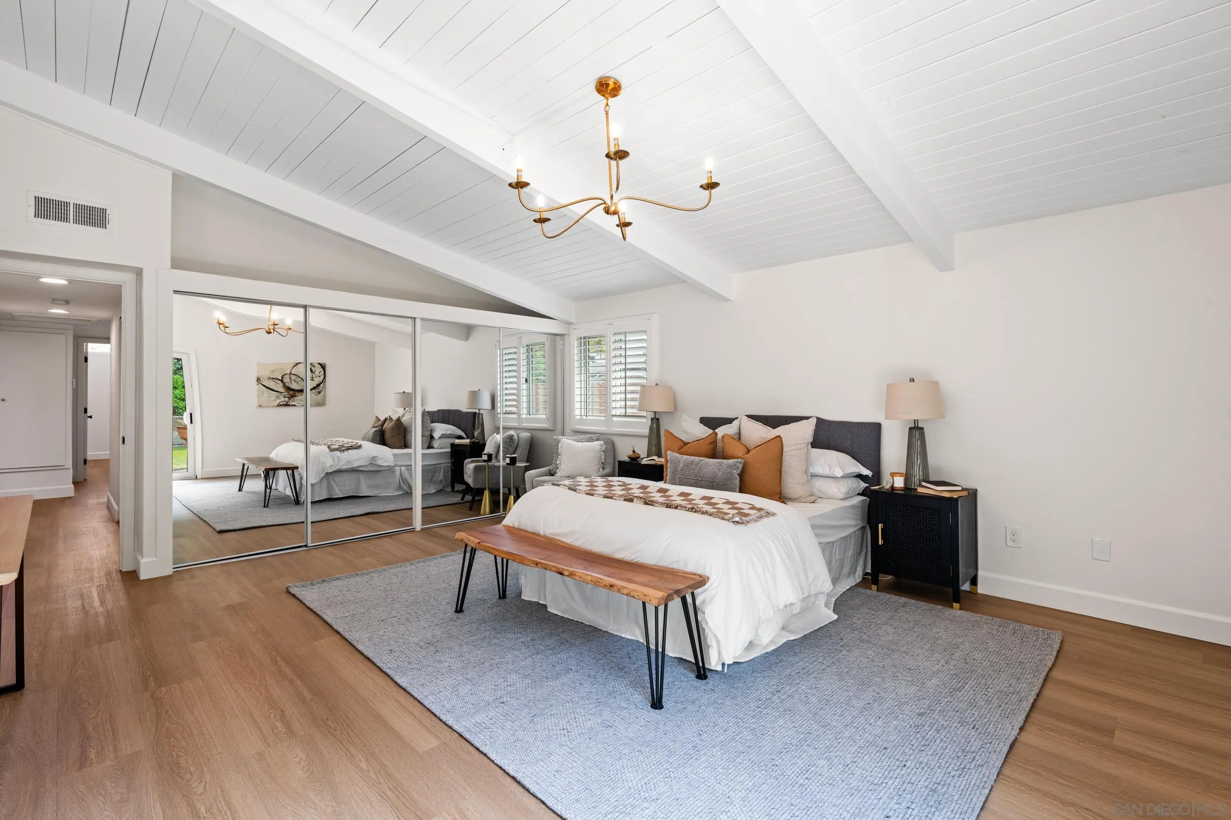 3448 Larga Circle San Diego, CA 92110 - Photo 18 of 36 a spacious bedroom with a bed a chandelier and window