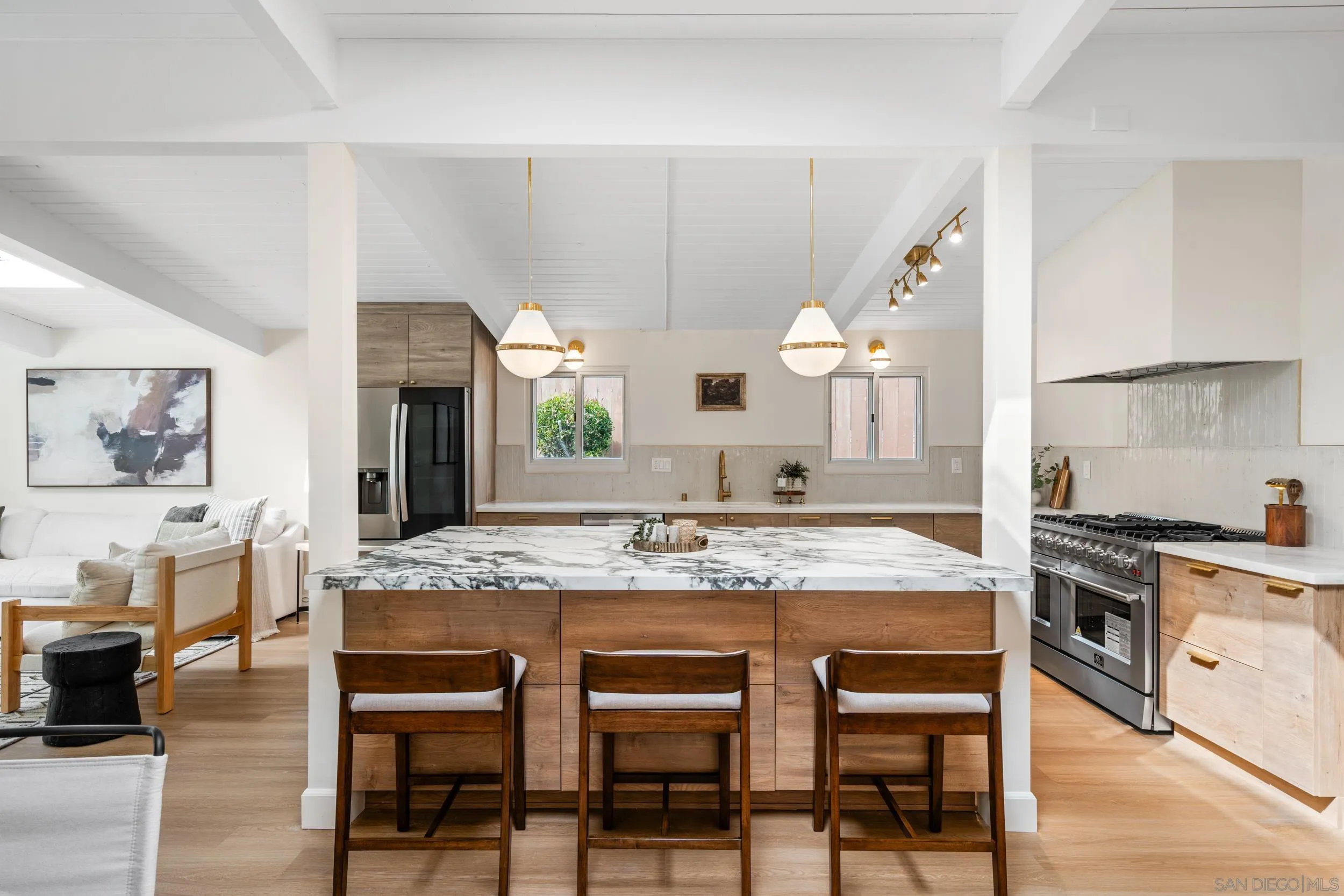 3448 Larga Circle San Diego, CA 92110 - Photo 10 of 36 a kitchen with kitchen island granite countertop a table chairs sink and cabinets