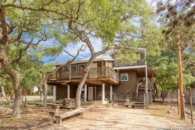 a front view of a house with a tree