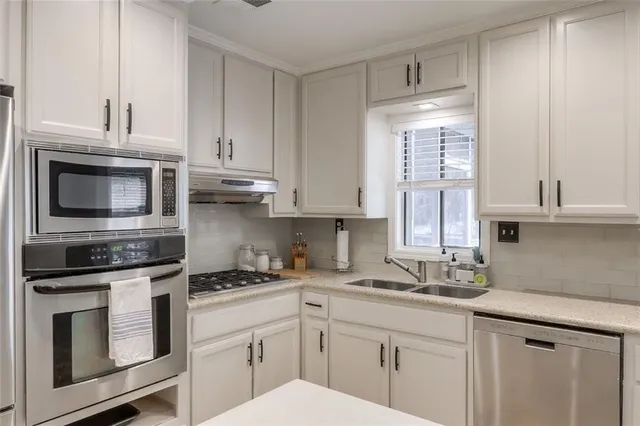a kitchen with stainless steel appliances granite countertop a sink a stove and cabinets