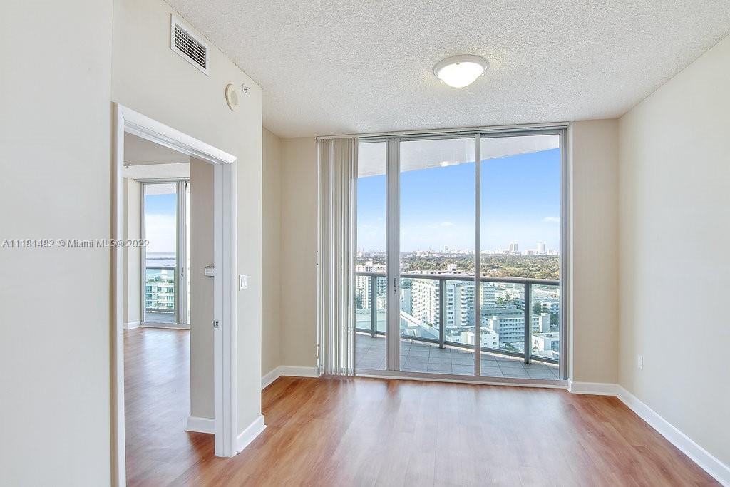 1500 Bay Road, Unit C2312 Miami Beach, FL 33139 - Photo 13 of 20 a view of an empty room with wooden floor and a window