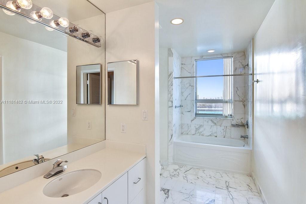 1500 Bay Road, Unit C2312 Miami Beach, FL 33139 - Photo 19 of 20 a bathroom with a sink double vanity granite tub shower and mirror
