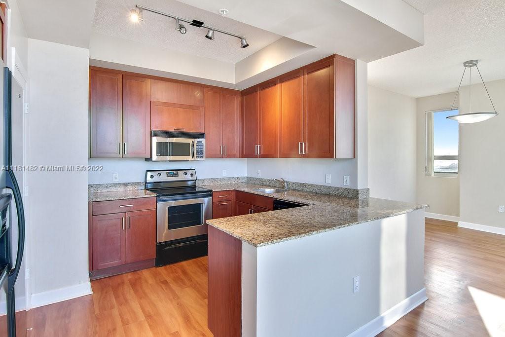 1500 Bay Road, Unit C2312 Miami Beach, FL 33139 - Photo 5 of 20 a kitchen with stainless steel appliances granite countertop a stove a sink and a microwave
