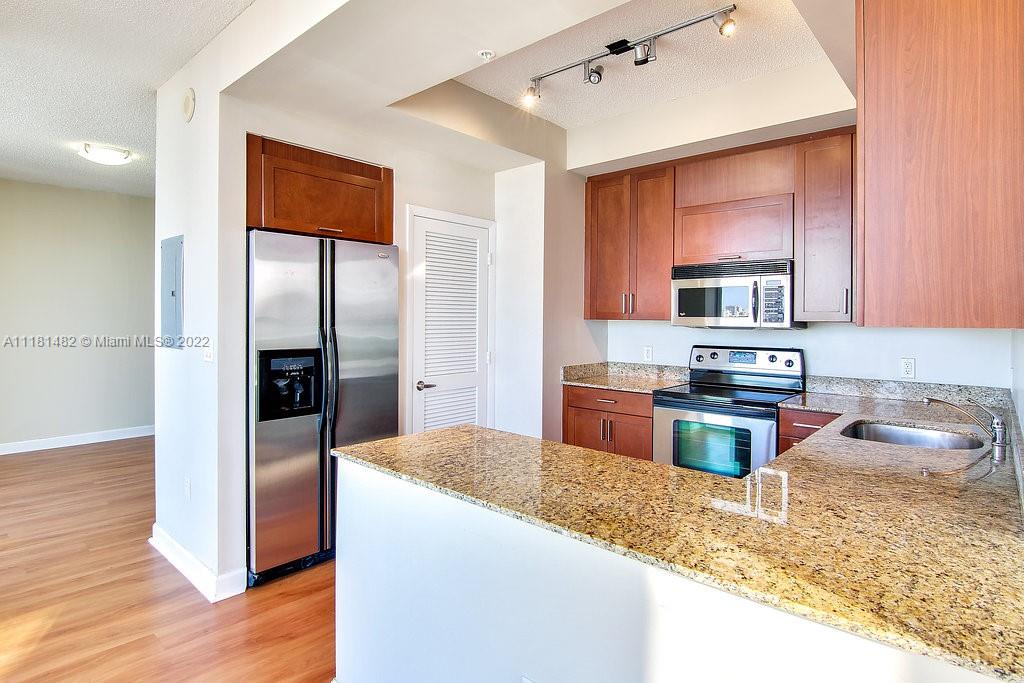 1500 Bay Road, Unit C2312 Miami Beach, FL 33139 - Photo 6 of 20 a kitchen with granite countertop a refrigerator and a sink