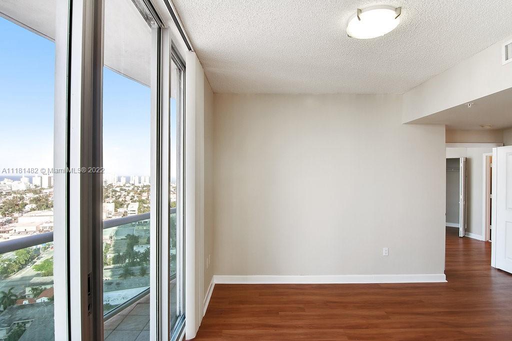 1500 Bay Road, Unit C2312 Miami Beach, FL 33139 - Photo 8 of 20 a view of an empty room with wooden floor and windows
