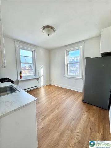 a view of a kitchen with wooden floor and a sink