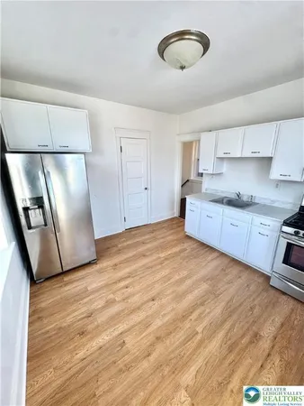 a large kitchen with a refrigerator and dishwasher