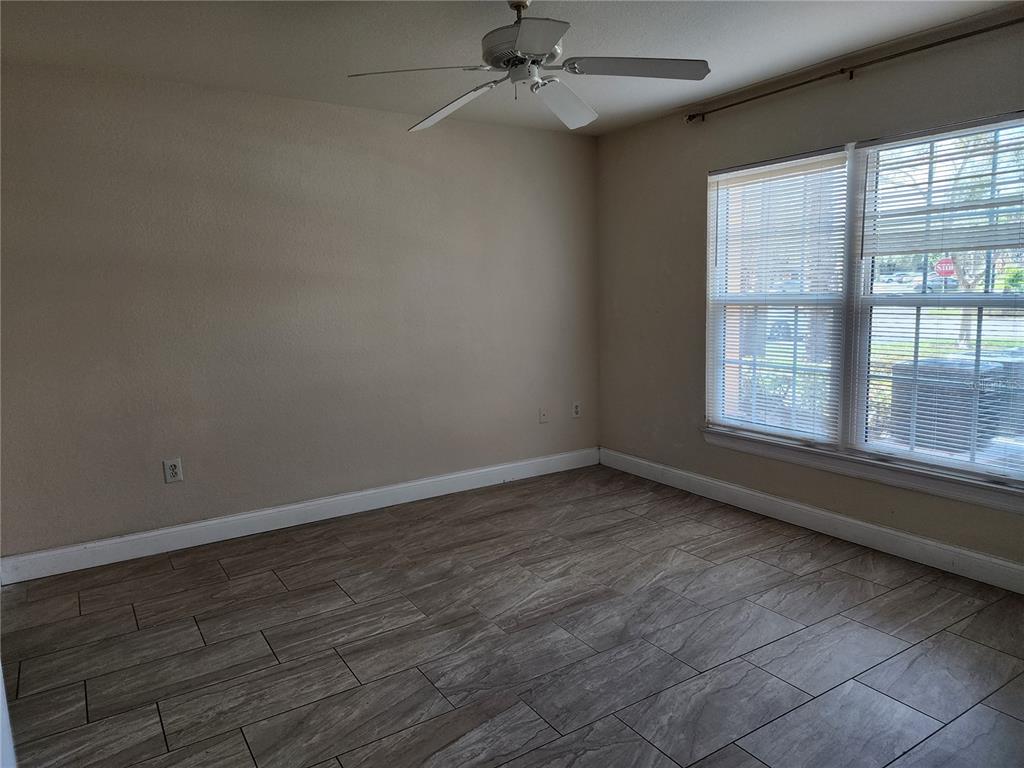 5455 Vineland Road, Unit 3105 Orlando, FL 32811 - Photo 4 of 11 an empty room with wooden floor and windows