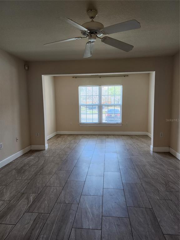 5455 Vineland Road, Unit 3105 Orlando, FL 32811 - Photo 5 of 11 an empty room with wooden floor and windows