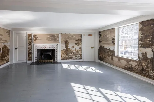 an empty room with windows and fireplace