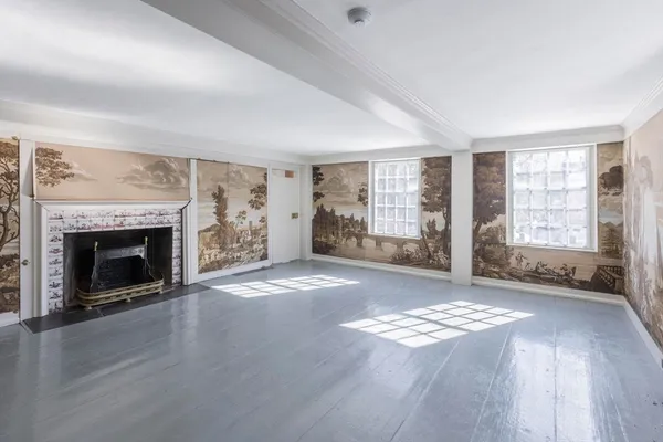 an empty room with windows and fireplace