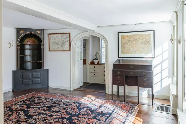 a living room with a couch and a dresser next to a window
