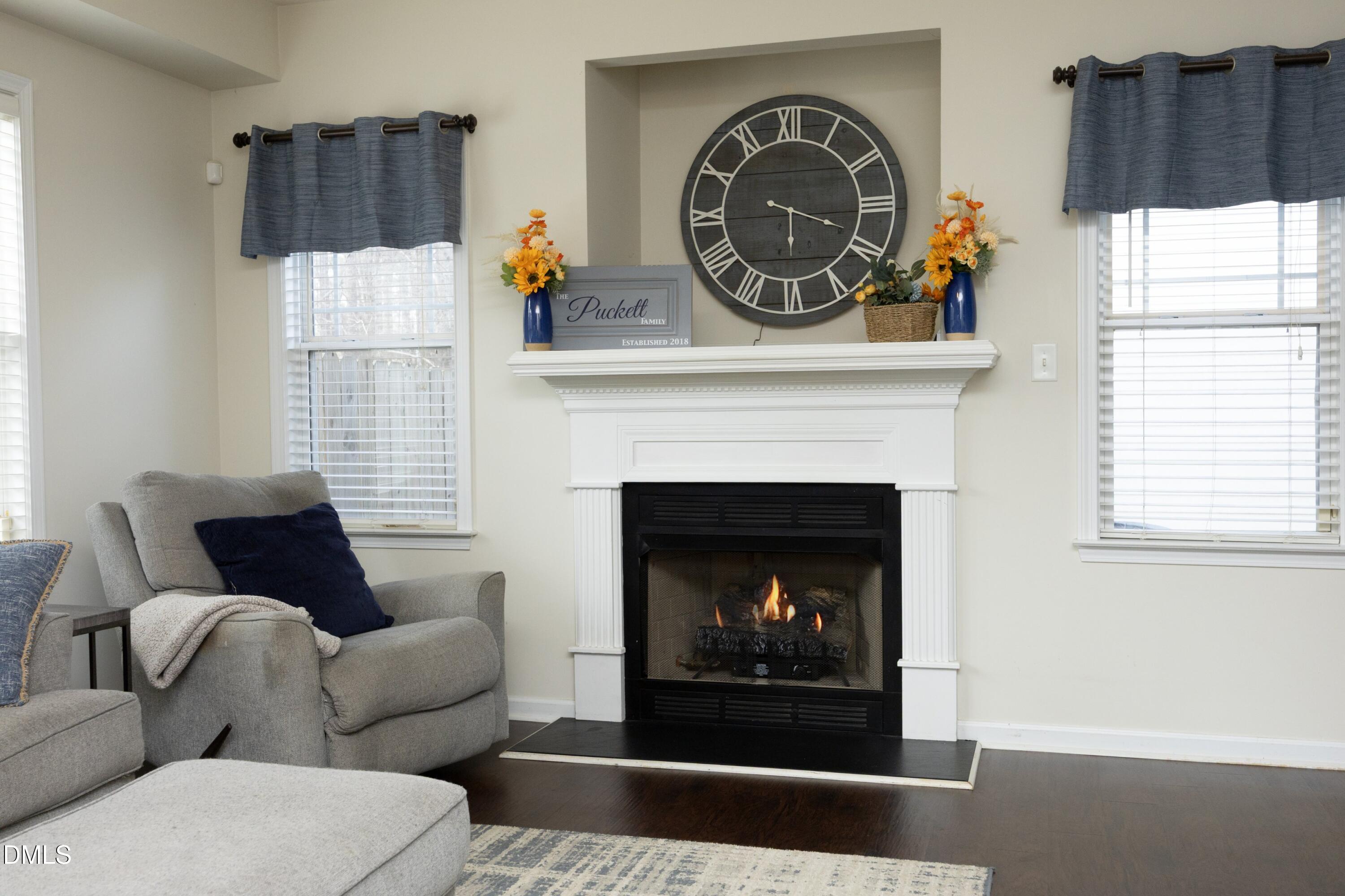 4054 Landover Lane Raleigh, NC 27616 - Photo 7 of 27 a living room with furniture a flat screen tv and a fireplace