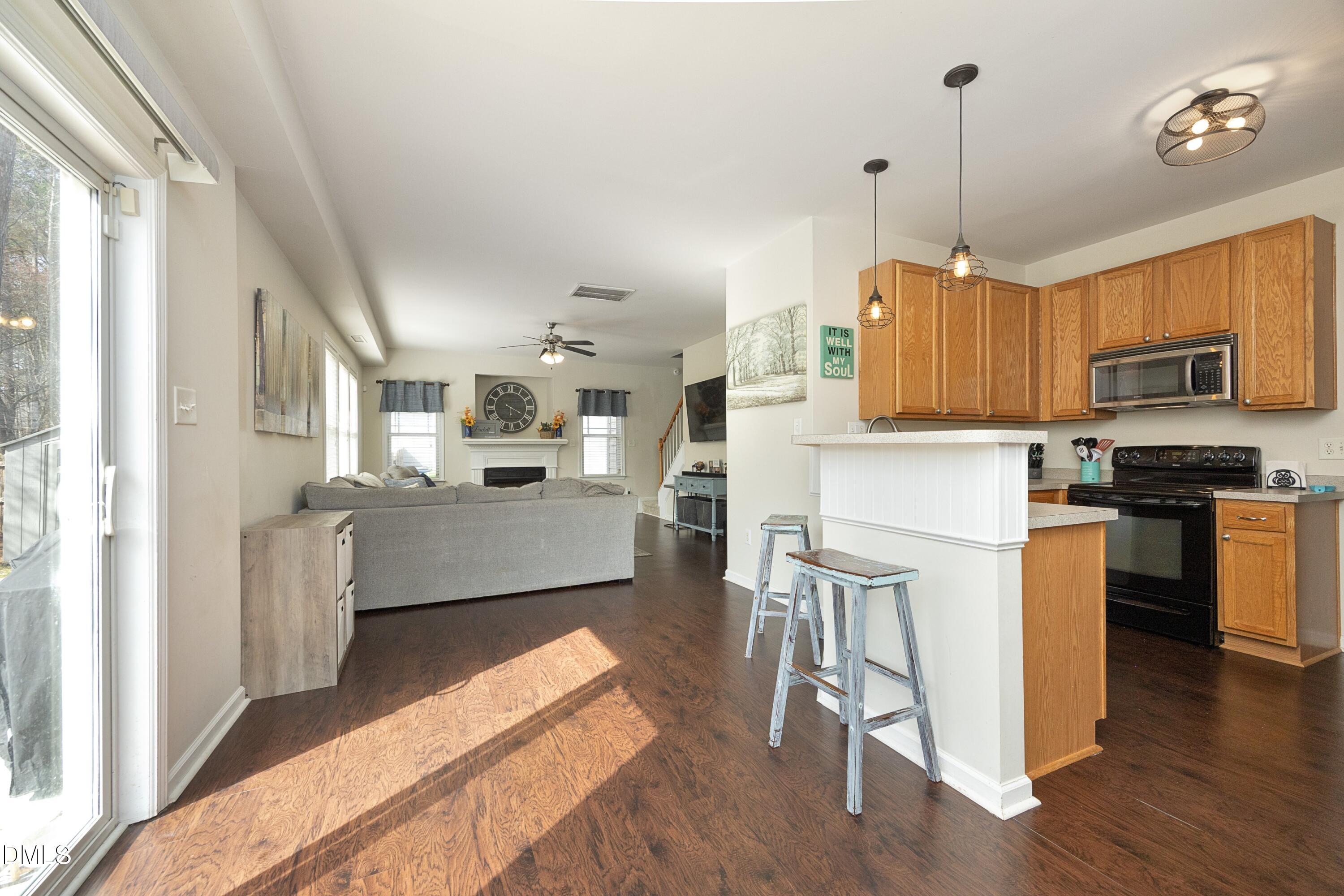 4054 Landover Lane Raleigh, NC 27616 - Photo 9 of 27 a kitchen with kitchen island granite countertop a stove top oven a sink dishwasher a dining table and chairs with wooden floor