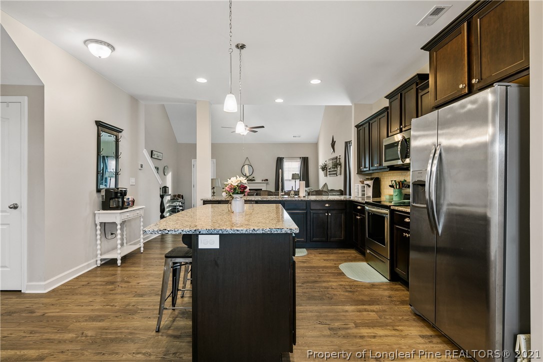 244 Mill Ridge Court Godwin, NC 28344 - Photo 11 of 50 a large kitchen with stainless steel appliances kitchen island granite countertop a large counter top cabinets and stainless steel appliances