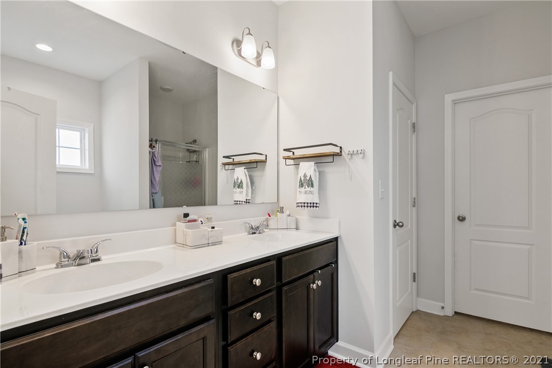 244 Mill Ridge Court Godwin, NC 28344 - Photo 27 of 50 a bathroom with double vanity sinks and a mirror