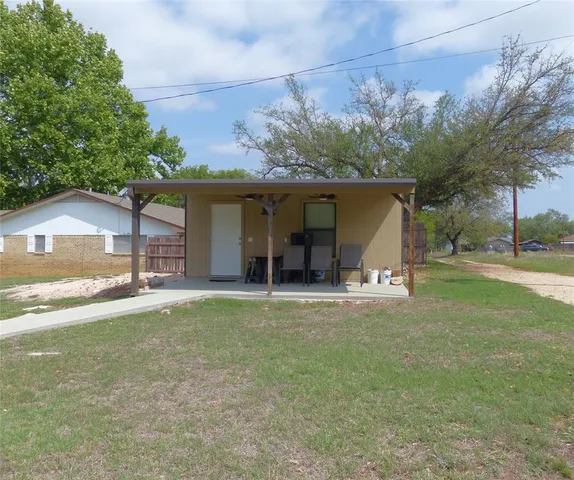 a front view of a house with a garden and trees