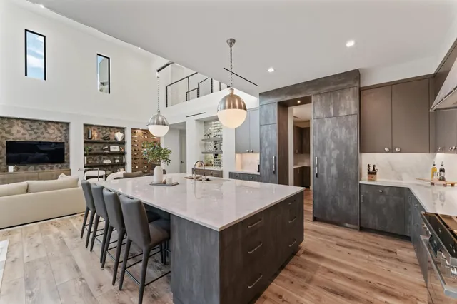 a kitchen with a dining table chairs sink and white cabinets