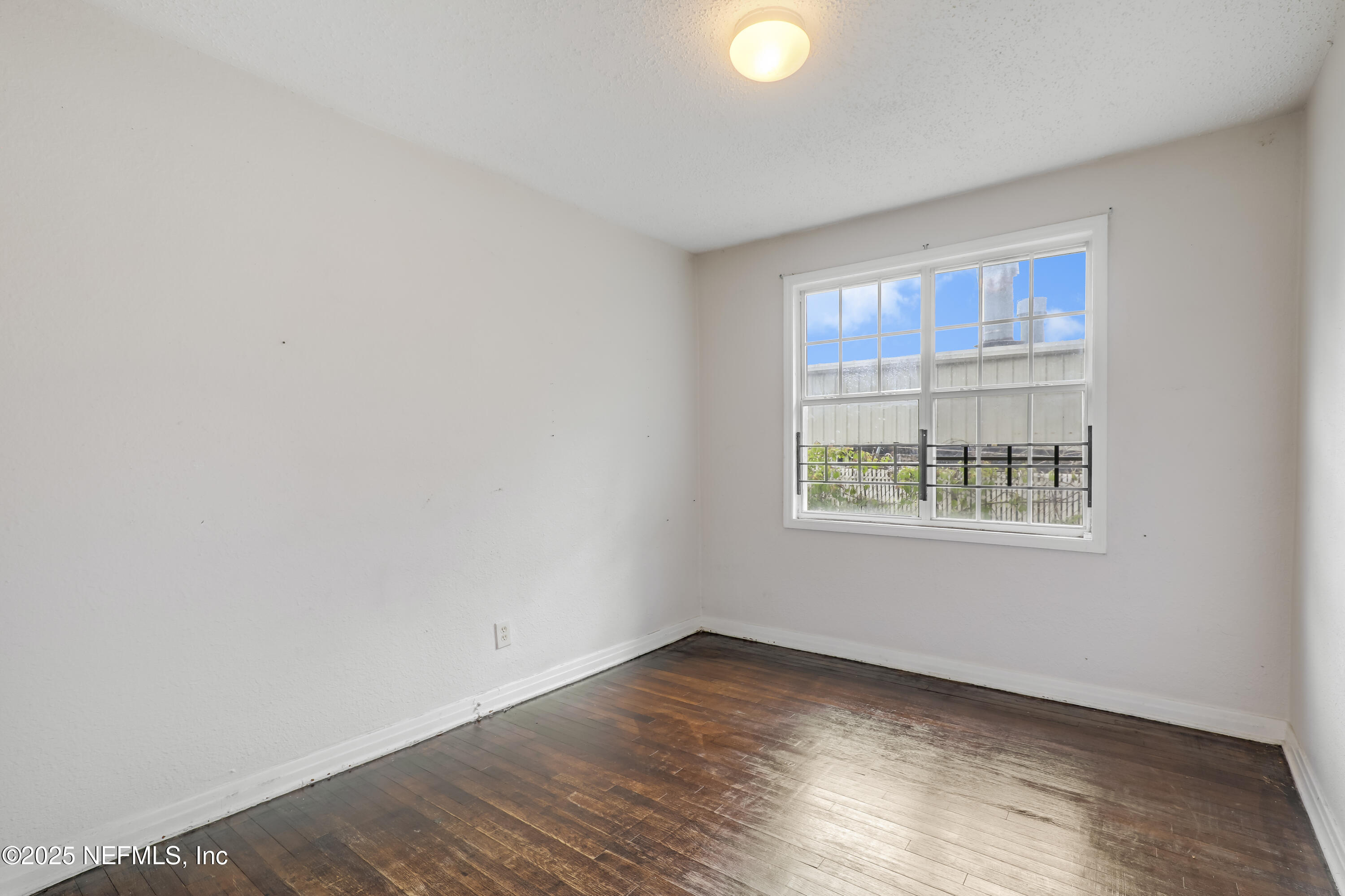 330 West 26th Street Jacksonville, FL 32206 - Photo 12 of 27 a view of an empty room with wooden floor and a window