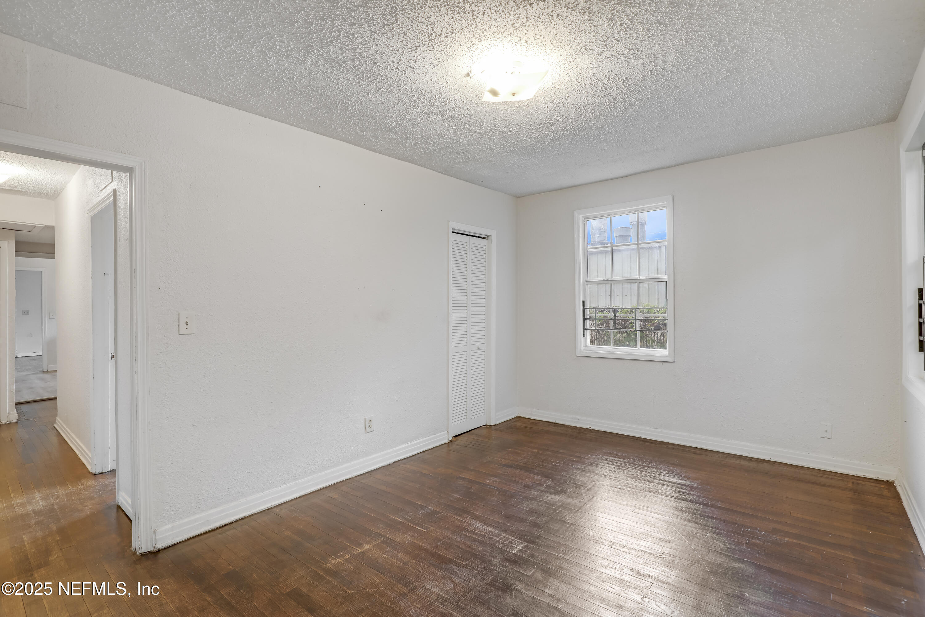 330 West 26th Street Jacksonville, FL 32206 - Photo 4 of 27 an empty room with wooden floor and windows