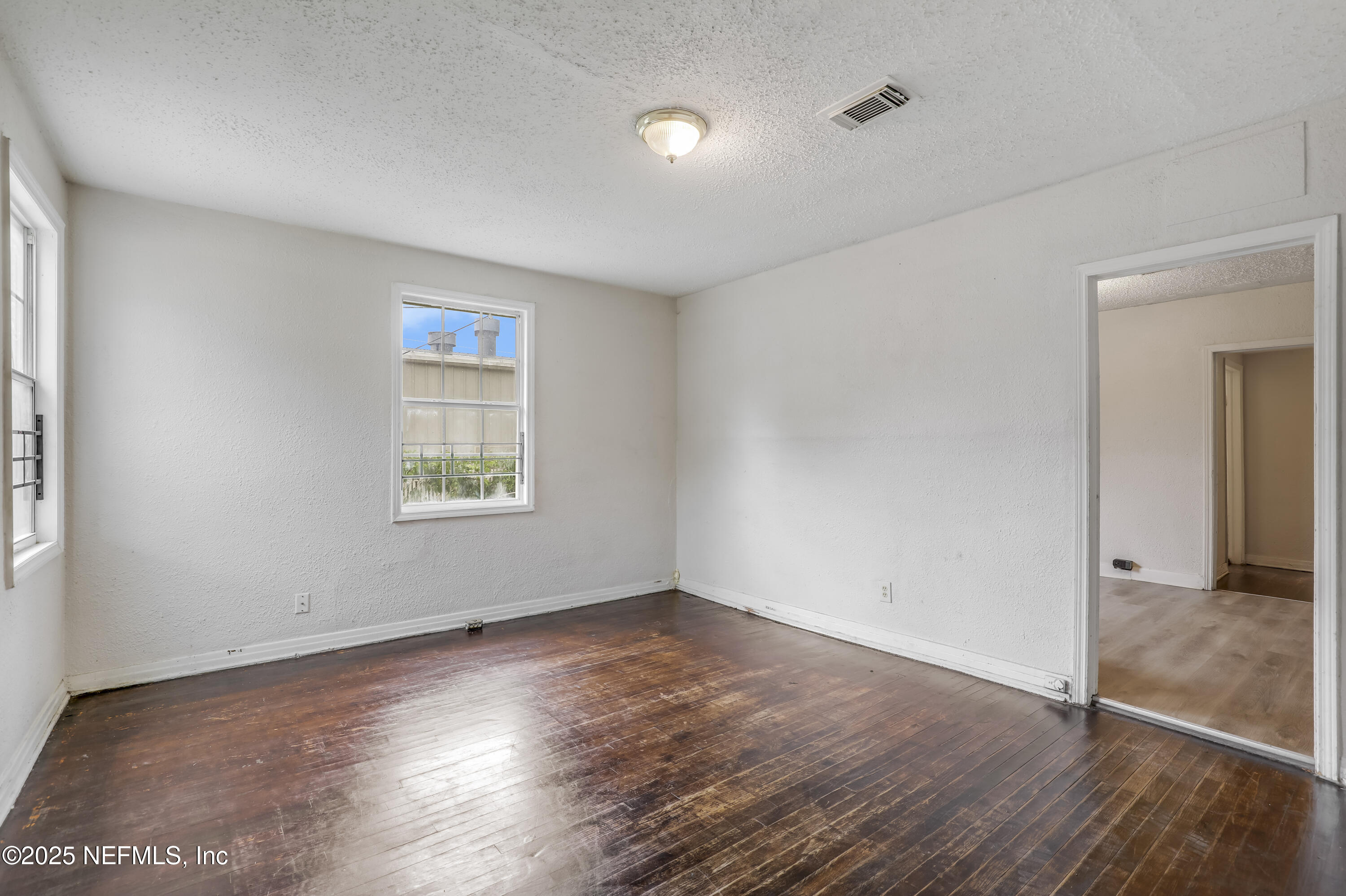 330 West 26th Street Jacksonville, FL 32206 - Photo 7 of 27 an empty room with wooden floor and windows
