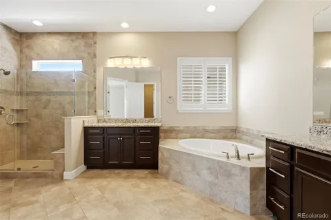 a bathroom with a tub sink shower and mirror