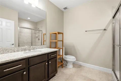 a bathroom with a sink a toilet a mirror and shower