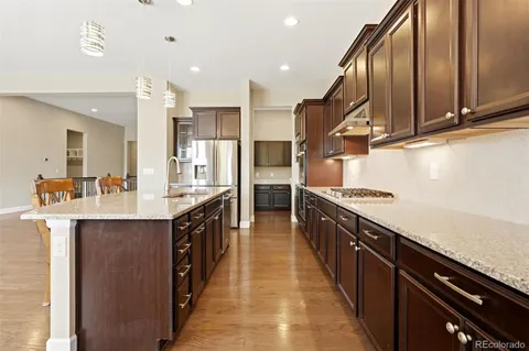 a large kitchen with stainless steel appliances lots of counter space and wooden floor