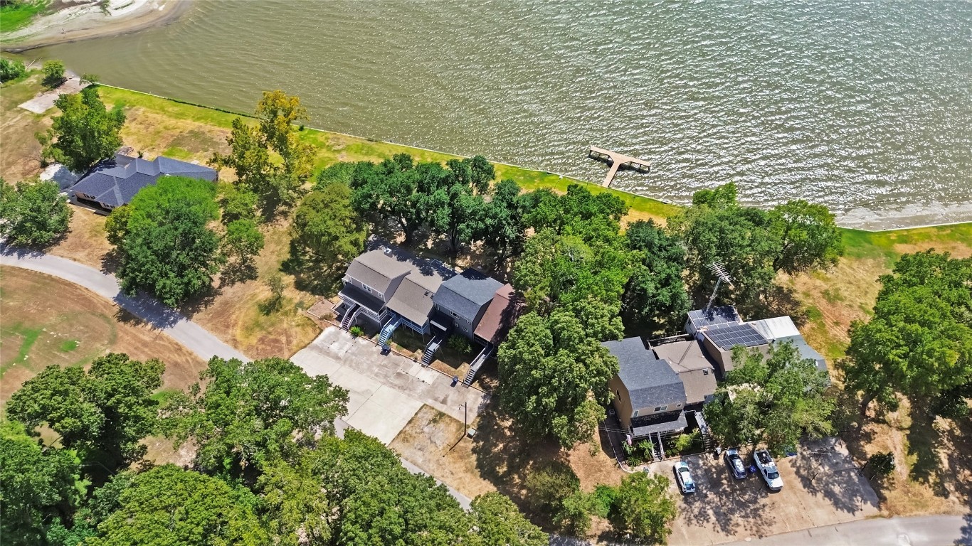 an aerial view of a house with a yard and lake view