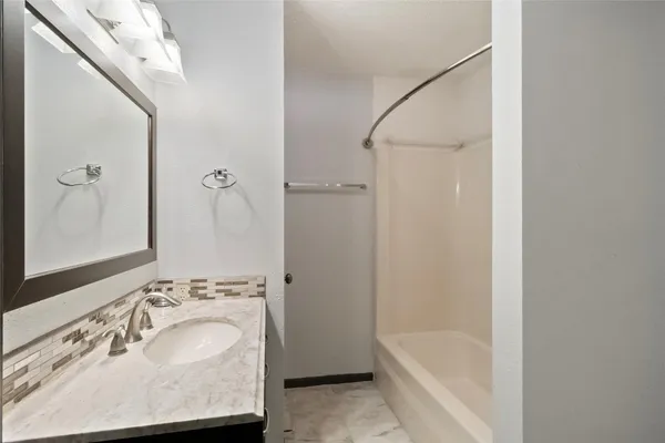 a bathroom with a tub sink and mirror