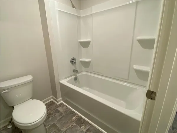 a white toilet sitting next to a bath tub