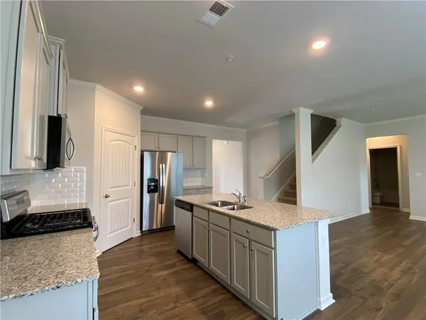 a kitchen with stainless steel appliances granite countertop a stove and a refrigerator