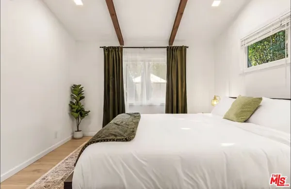 a bedroom with a large bed and a potted plant