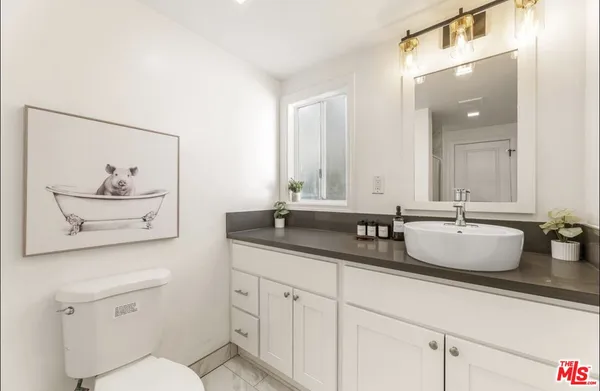 a bathroom with 2 sink and a mirror with toilet