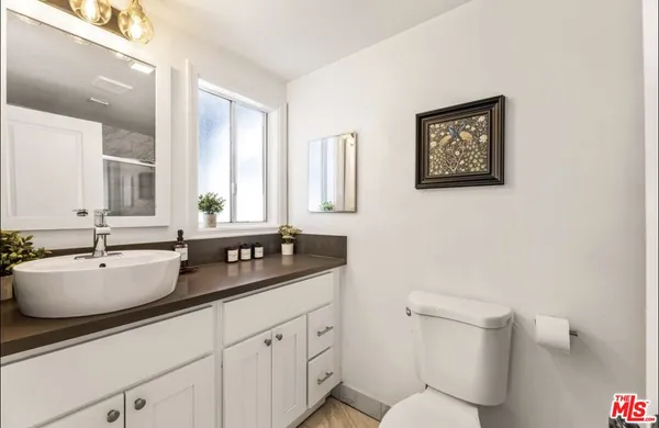 a bathroom with a toilet a sink and mirror
