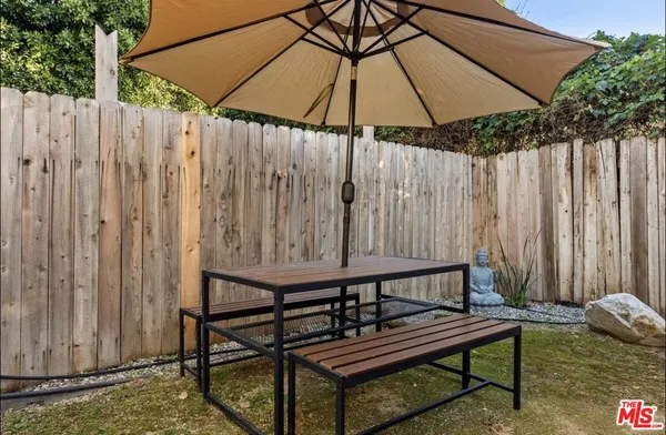 a wooden bench sitting in front of a wooden fence