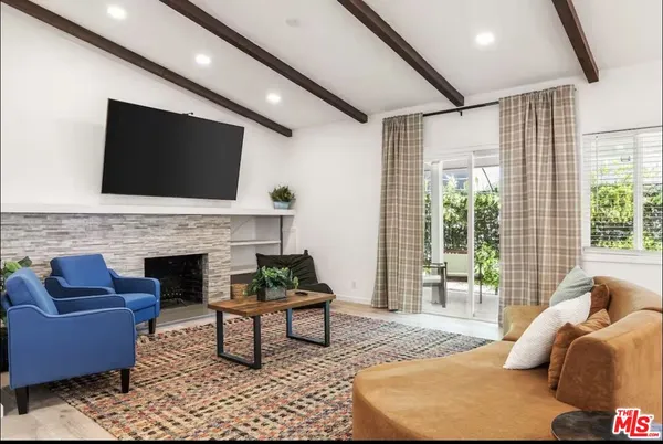 a living room with furniture a flat screen tv and a fireplace