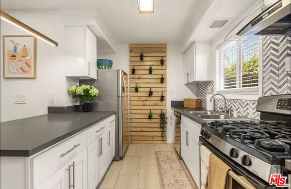 a kitchen with stainless steel appliances granite countertop a stove a sink and a granite counter tops