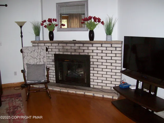 a living room with a fireplace furniture and a potted plant