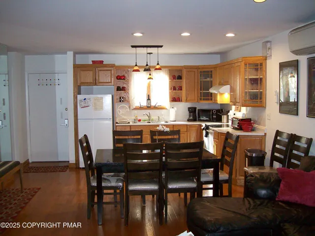 a kitchen with stainless steel appliances kitchen island granite countertop a table chairs and a refrigerator