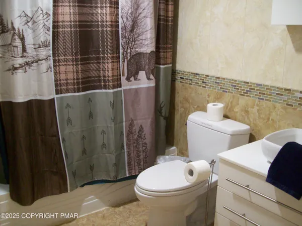 a white toilet sitting next to a bathroom sink and a shower