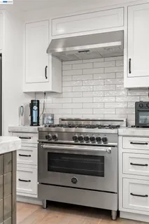 a kitchen with stainless steel appliances kitchen island granite countertop a table chairs refrigerator and sink