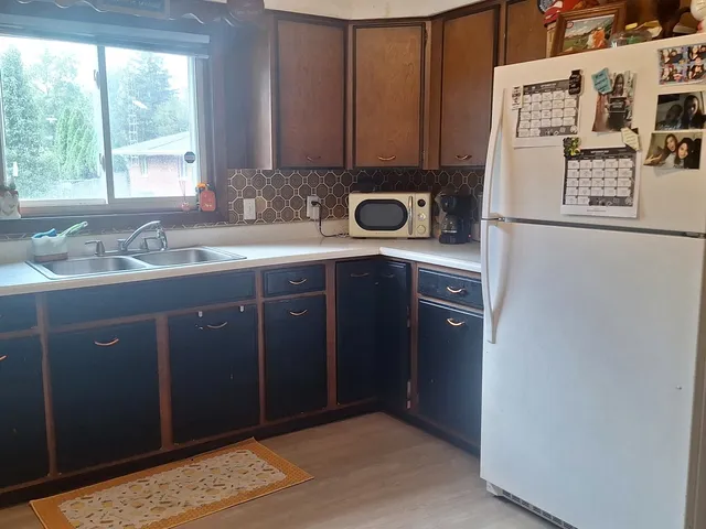 a kitchen with stainless steel appliances granite countertop a sink a refrigerator and a stove